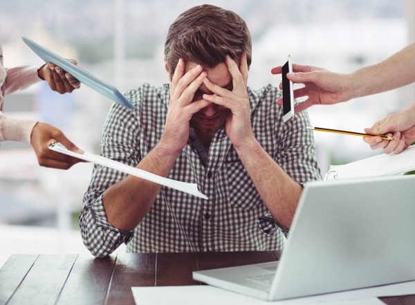 Stressed man frustrated with electronic devices in office